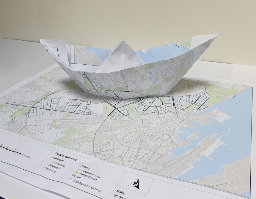 A paper ship shaped from a water network map